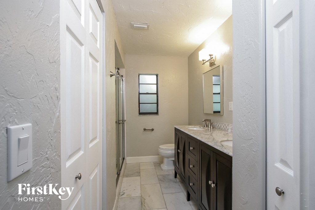 a bathroom with a toilet and a sink and a shower