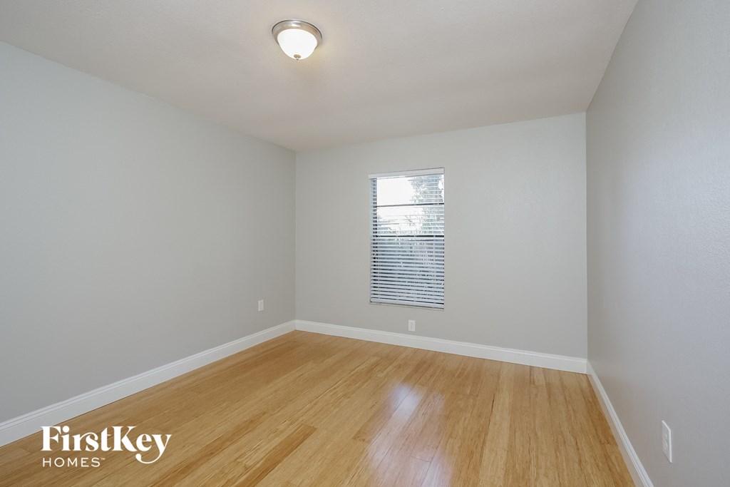 the spacious living room with hardwood flooring and window