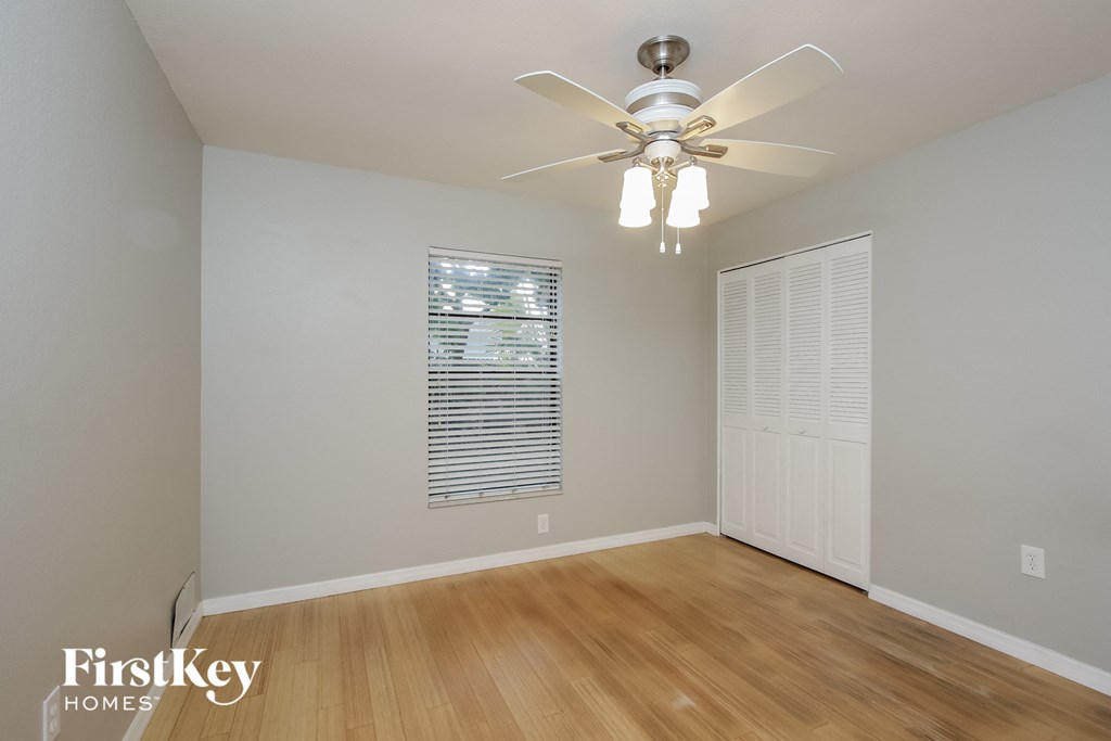 a bedroom with a ceiling fan and a window