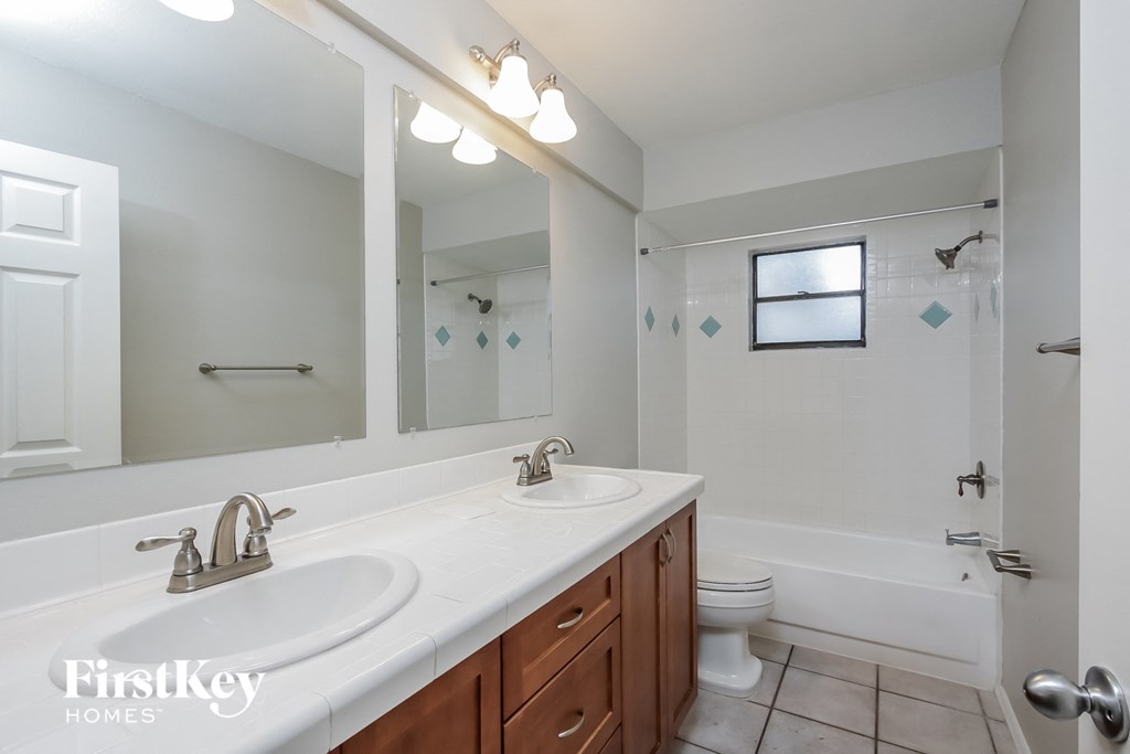 a bathroom with two sinks and a shower and a toilet