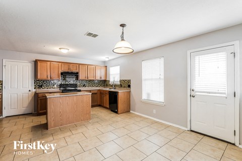 a large kitchen with wood cabinets and tile flooring