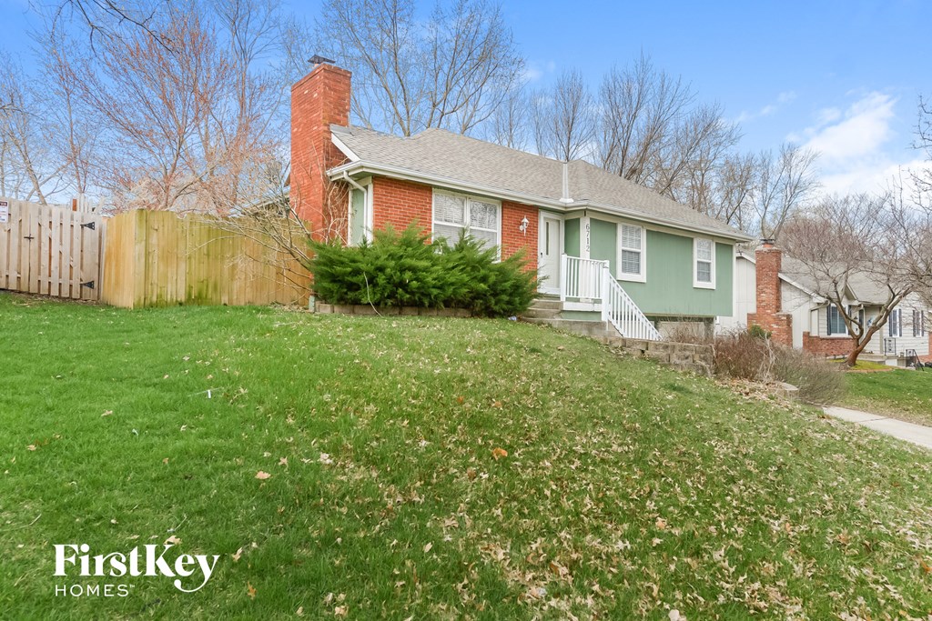 a green house with a yard and a fence