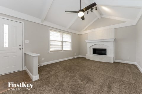 a living room with a fireplace and a ceiling fan