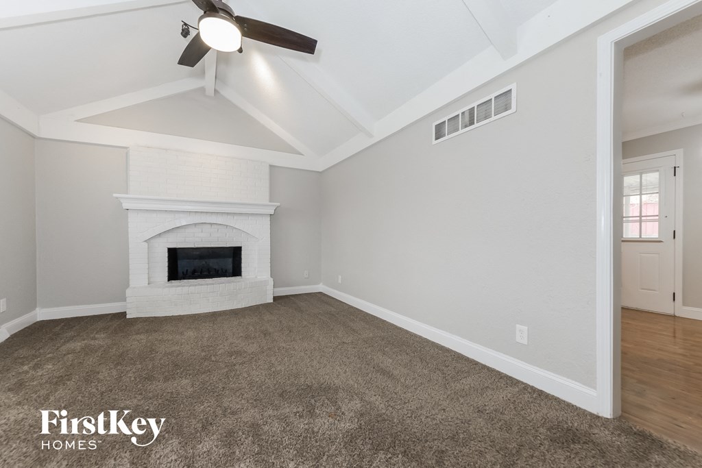 a living room with a fireplace and a ceiling fan
