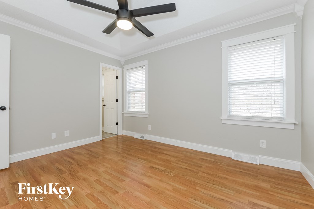 the living room with wood floors and a ceiling fan