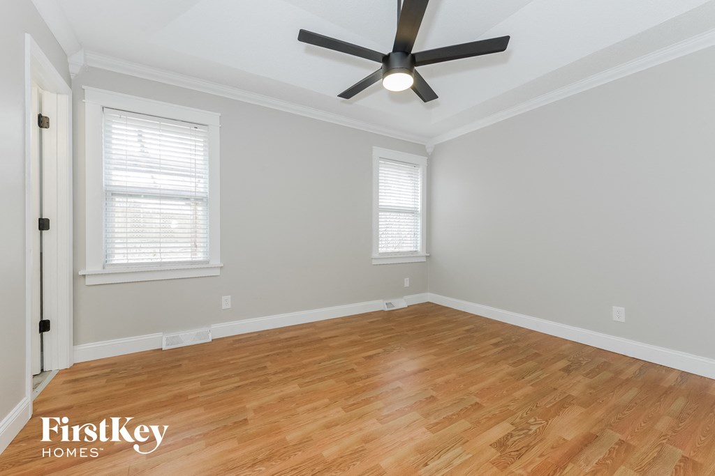 the living room with wood floors and a ceiling fan