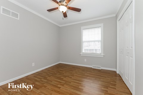 the second bedroom with hardwood flooring and a ceiling fan