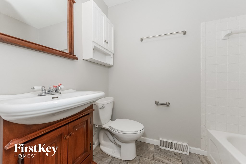 a bathroom with a toilet and a sink and a mirror