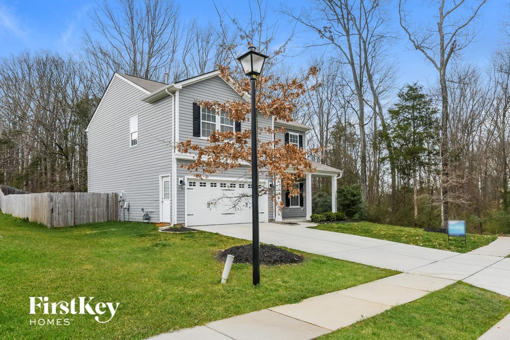 the front of a gray house with a street light in front of it