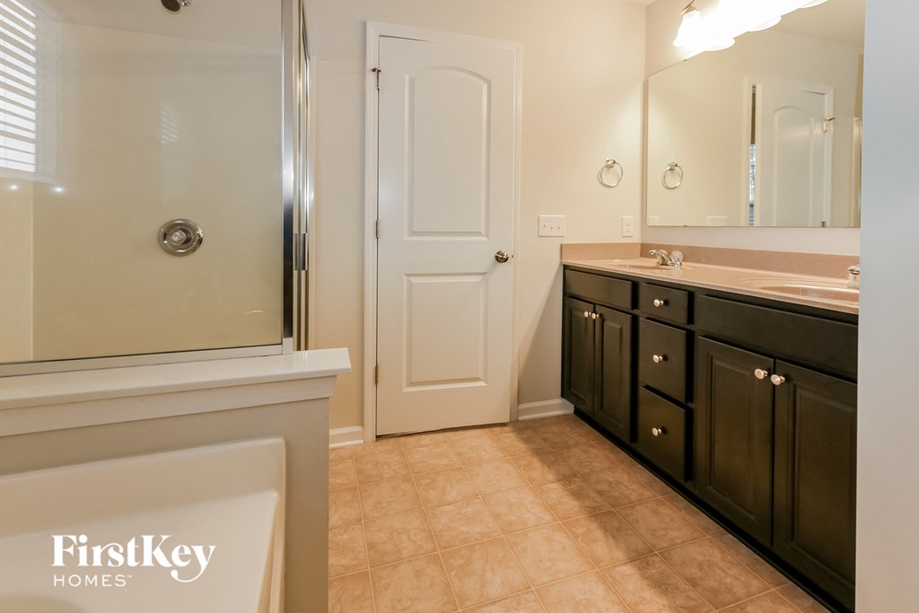 a bathroom with a shower and a sink and a mirror