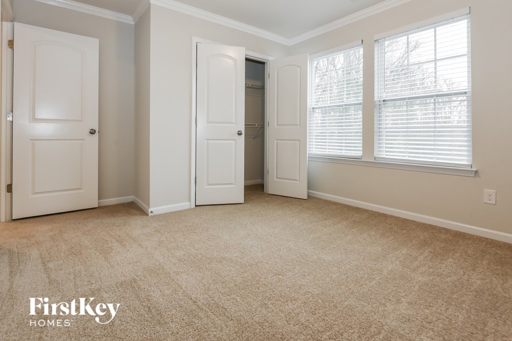 an empty living room with three doors and a closet