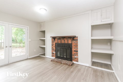 A living room with a fireplace and built-in shelves.