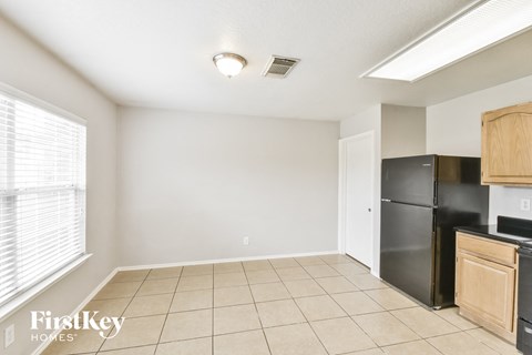 a kitchen with a black refrigerator and a window