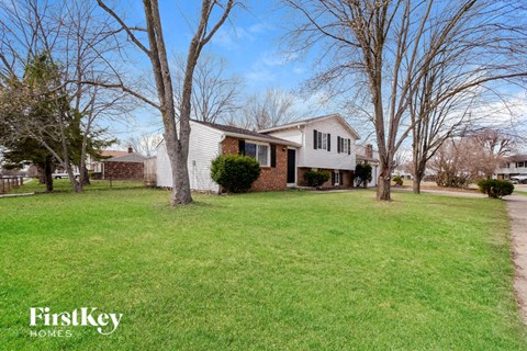 A house with a lawn and trees in front of it.