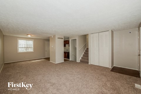A spacious room with a staircase leading to another level.