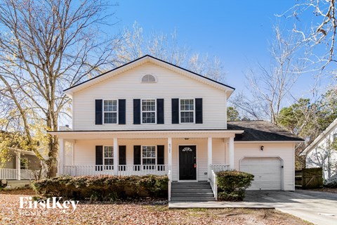 a white house with black shutters and a black front door