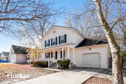 a white house with black shutters and a garage door
