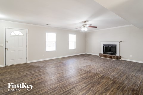 the living room with wood flooring and a fireplace