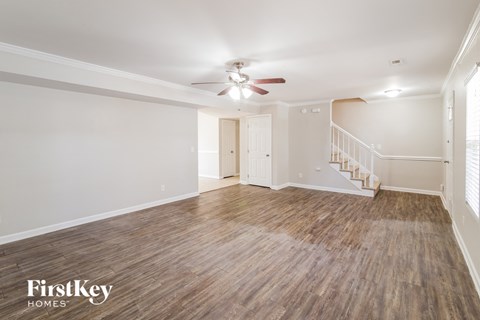 a living room with wood flooring and a ceiling fan