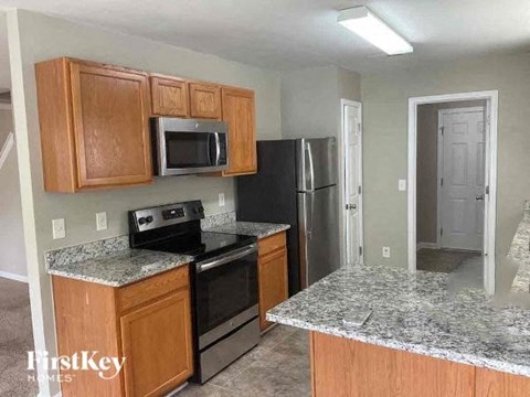 A kitchen with granite countertops and wooden cabinets.
