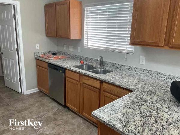 A kitchen with granite countertops and wooden cabinets.