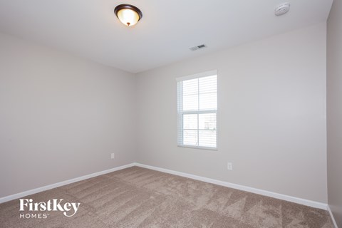 the living room of a new home with white walls and a window