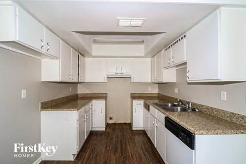 A kitchen with white cabinets and a granite countertop.