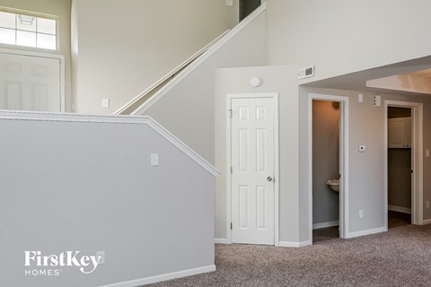 a bedroom with a door to a closet and a staircase