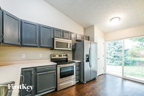 A kitchen with dark cabinets and stainless steel appliances.