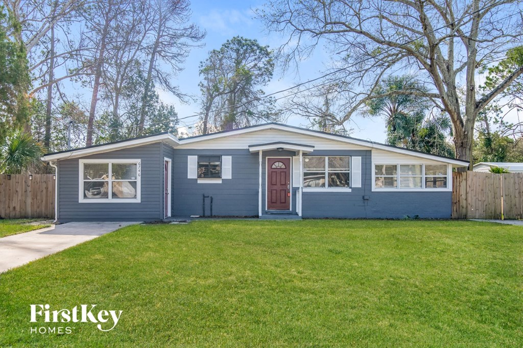 a blue house with a yard and a red door