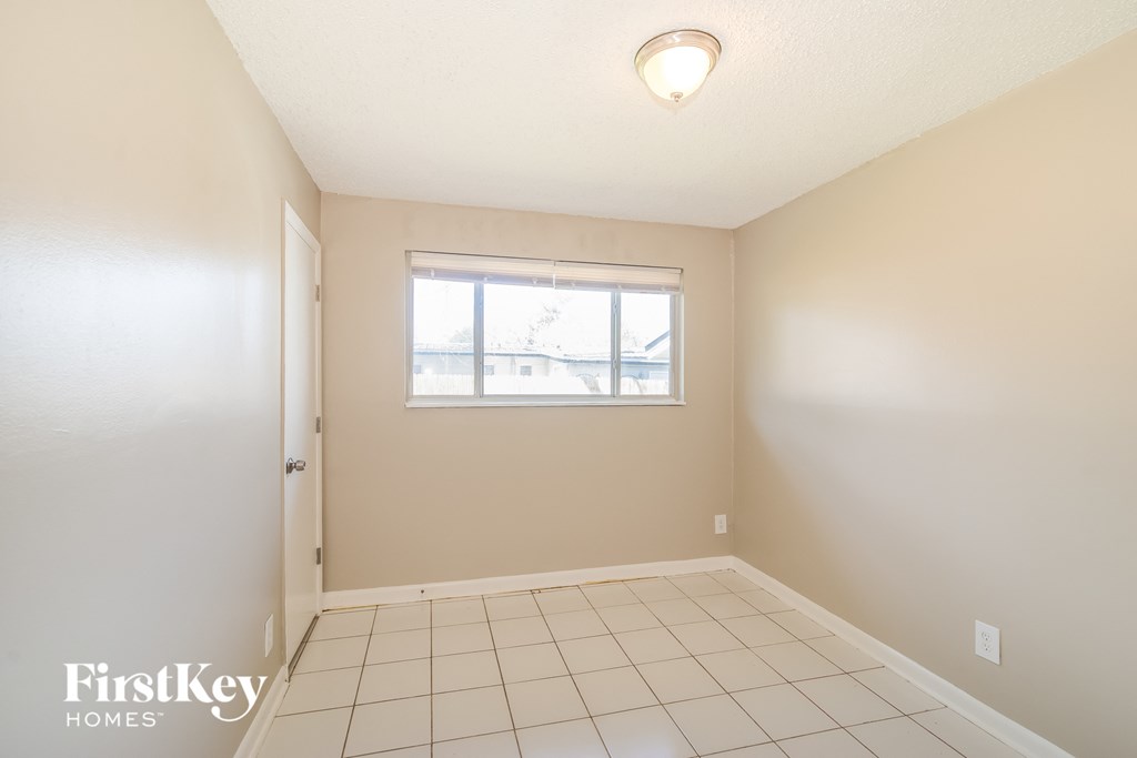a empty room with a window and a tiled floor