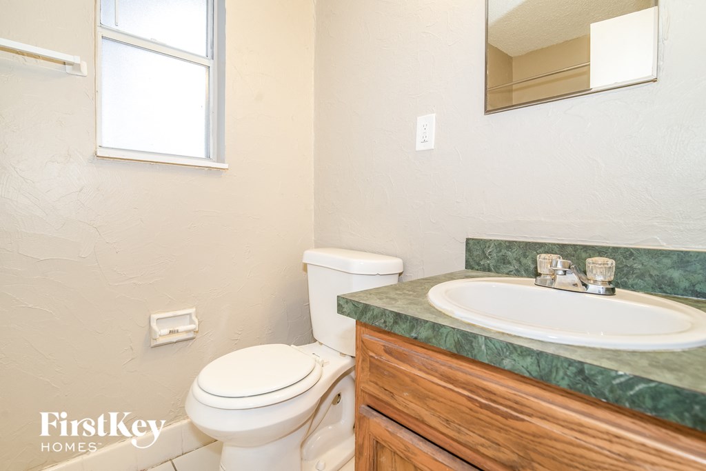 a bathroom with a toilet and a sink and a mirror