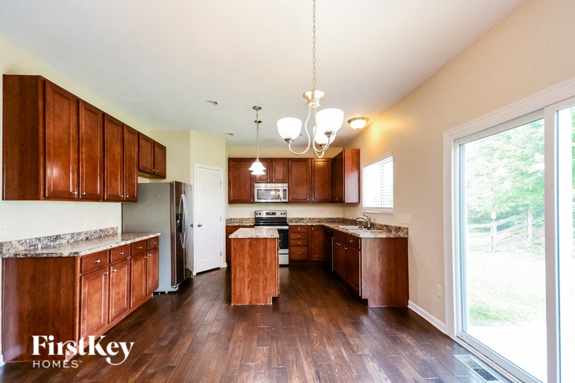 a kitchen with wooden cabinets and a large window