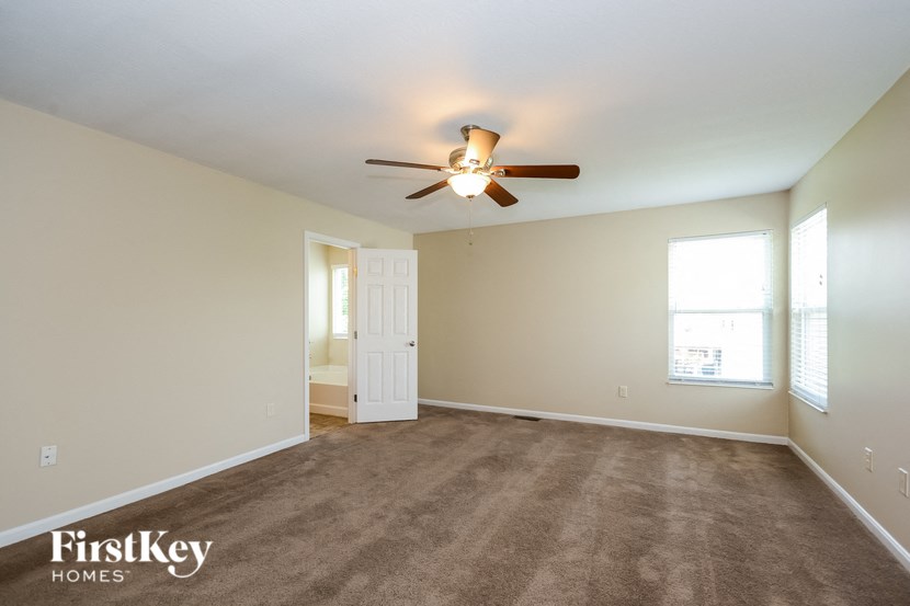 a living room with carpet and a ceiling fan