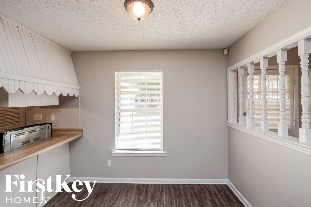 A room with a window and a wooden shelf.