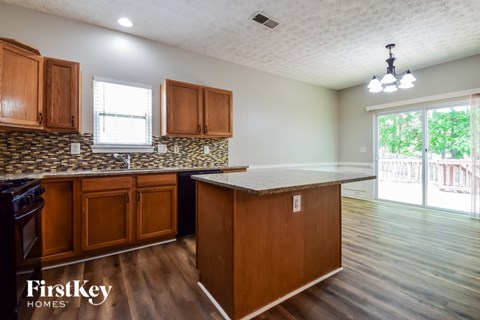 A kitchen with wooden cabinets and a stone backsplash.