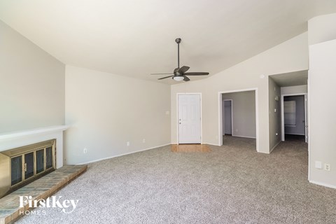 a living room with carpet and a ceiling fan