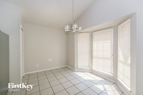 a dining room with large windows and a tiled floor