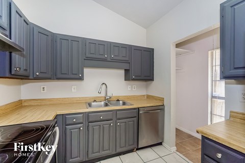 a kitchen with blue cabinets and a stainless steel sink