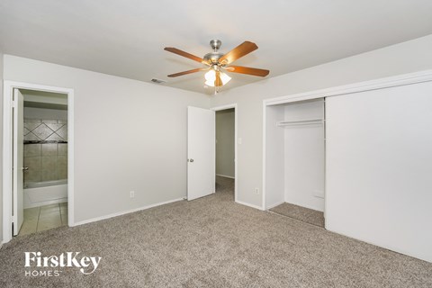 a bedroom with a ceiling fan and a closet