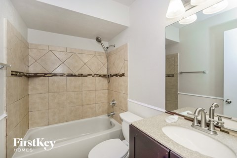 a bathroom with a tub and a sink and a toilet