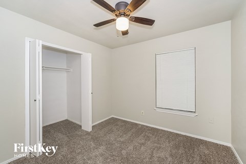 a bedroom with a ceiling fan and a closet