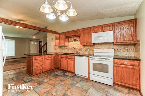 a kitchen with white appliances and wooden cabinets