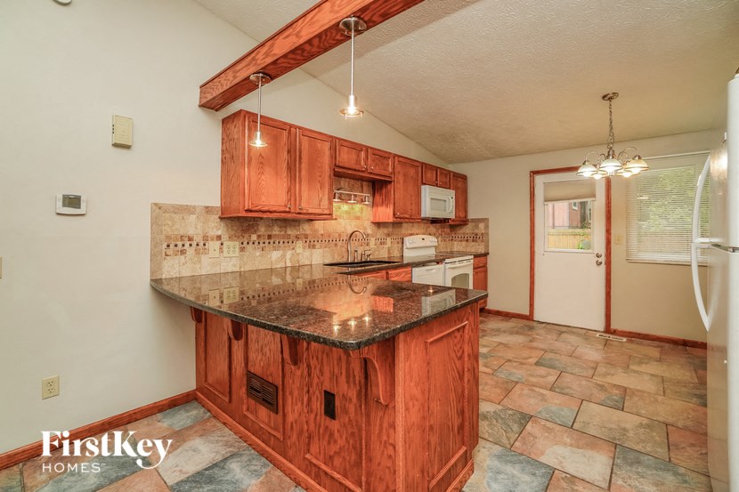 the kitchen has granite counter tops and wood cabinets