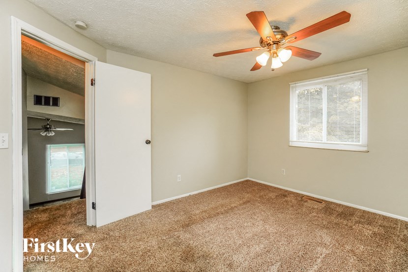 an empty bedroom with a ceiling fan and a closet