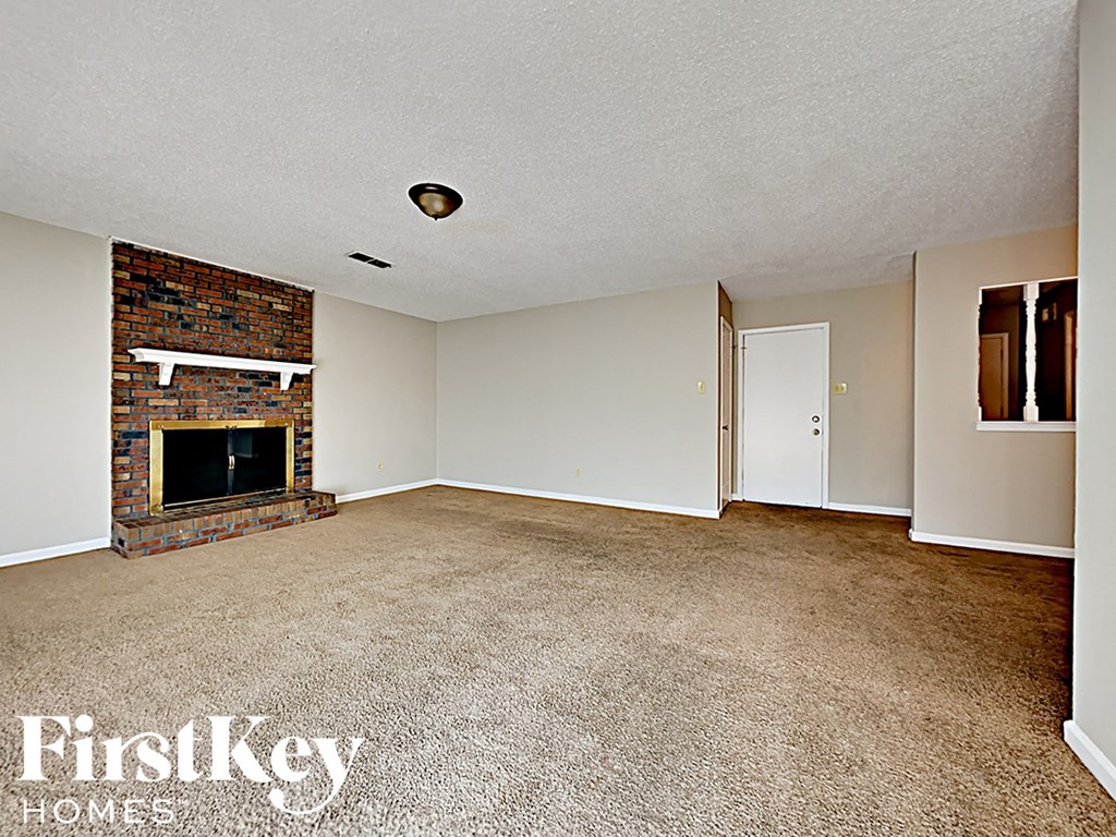 A room with a fireplace and a carpeted floor.