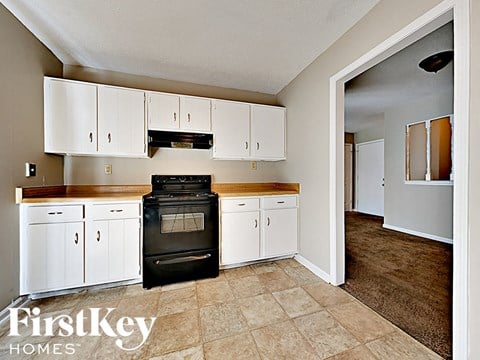 A kitchen with white cabinets and a black stove top oven.
