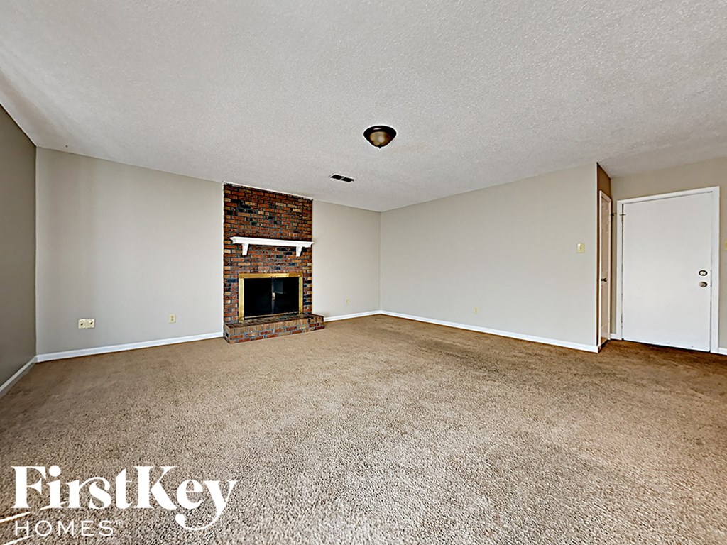 A room with a fireplace and a carpeted floor.