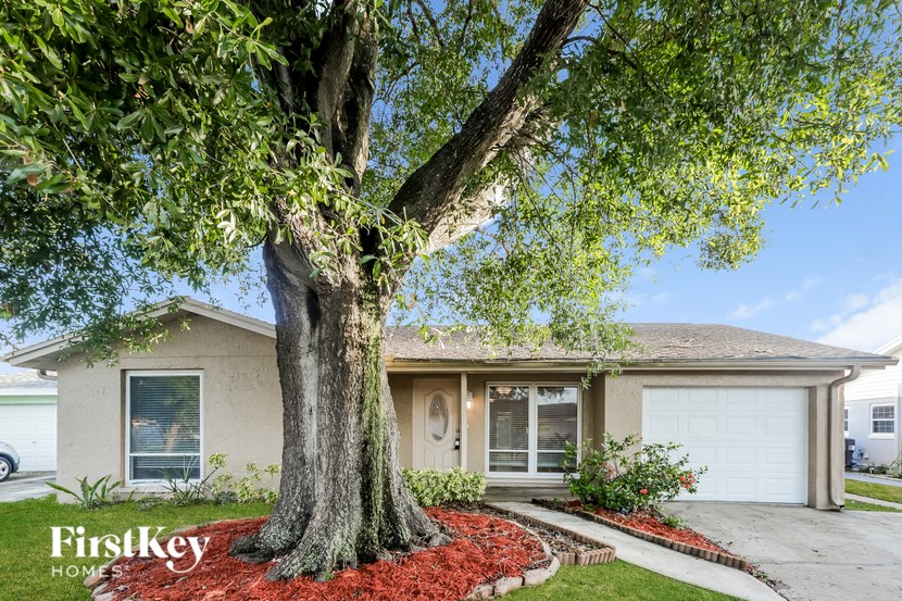 A tree in front of a house with the words "FirstKey Homes" on the bottom left.