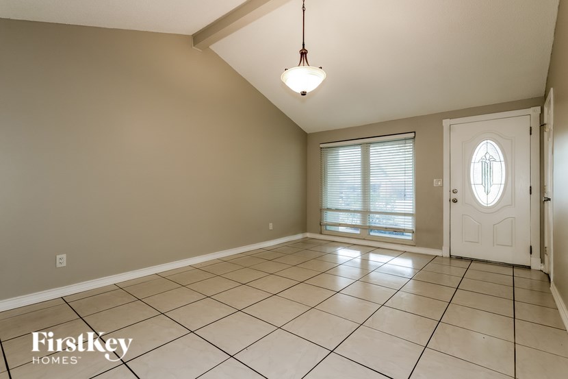 A room with a white door and a light hanging from the ceiling.